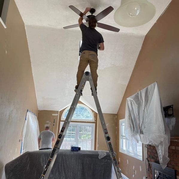 Roll With It painter preparing a living room ceiling